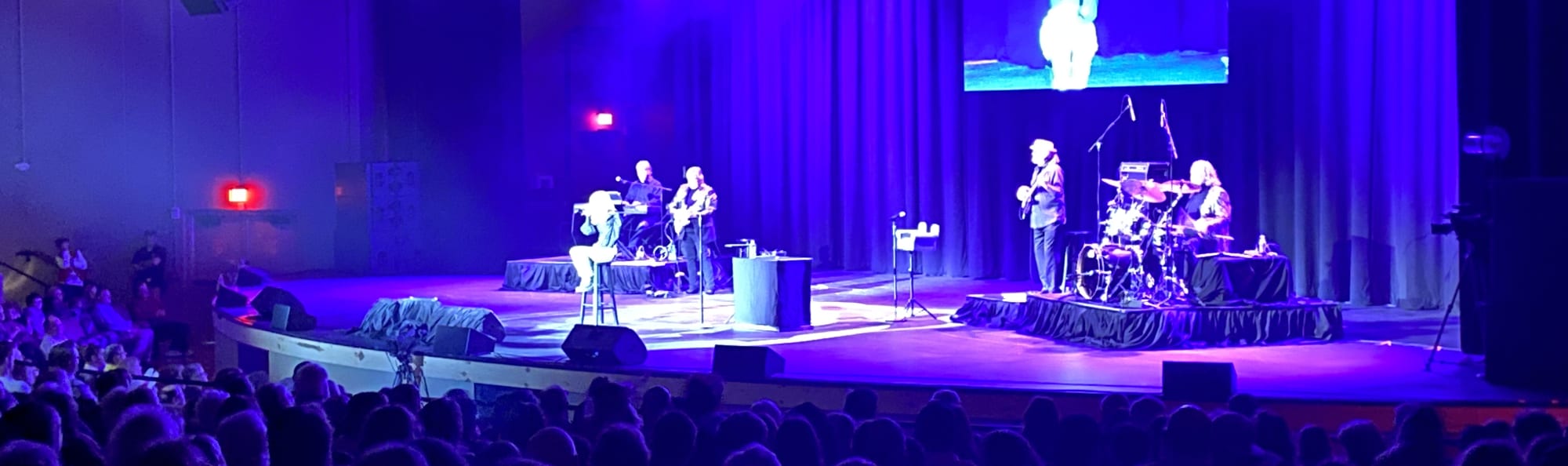 signer on stage in chair washed out by the lights Miami